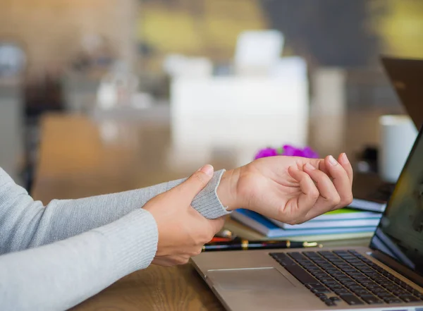 Closeup woman holding her wrist pain from using computer — Stock Photo, Image