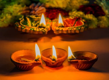 Çiçekler için Diwali Festivali ile geleneksel kil diya lambalar yaktı