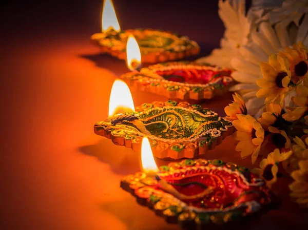 Kolorowe gliny diya żarówkami świecącymi z kwiatami dla hinduskiego Diwali — Zdjęcie stockowe