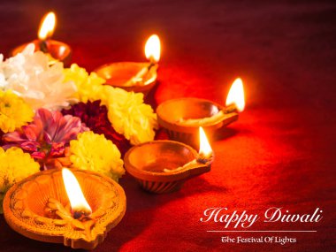 Çiçekler için Diwali Festivali ile geleneksel kil diya lambalar yaktı