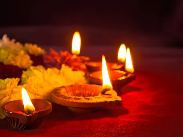 Lámparas tradicionales de diya de arcilla encendidas con flores para el festival Diwali —  Fotos de Stock