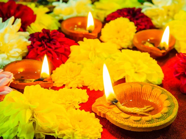 Çiçekler için Diwali Festivali ile geleneksel kil diya lambalar yaktı