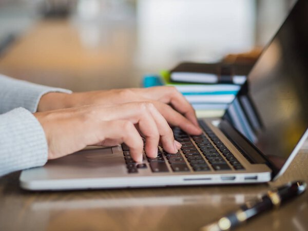 Woman hand working on her laptop with selective focus. 