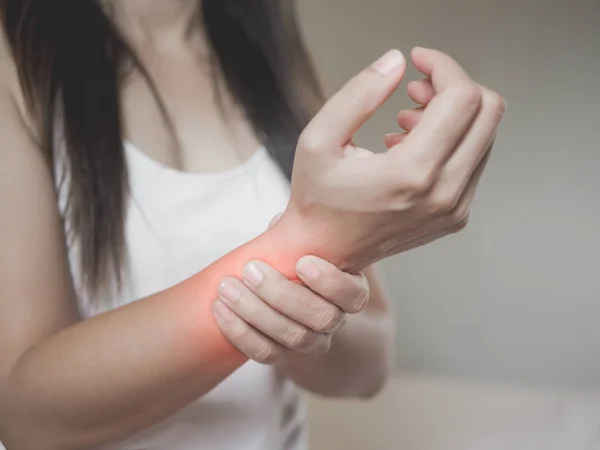 Mujer de primer plano sostiene su lesión en la mano de la muñeca, sintiendo dolor . — Foto de Stock