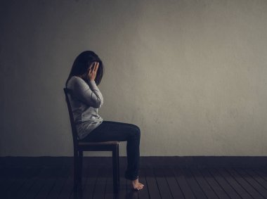 Depresif kadın evde karanlık odada bir sandalyede oturuyordu.