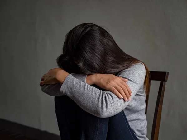 Depresif kadın evde karanlık odada bir sandalyede oturuyordu. — Stok fotoğraf