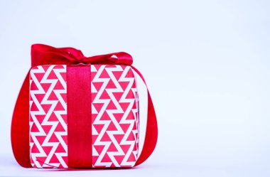Beyaz zemin üzerine kırmızı kurdele ile bir hediye kutusu.. 