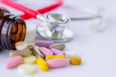 Steteskop ve pill şişe arka plan haplarla yumuşak odak. 
