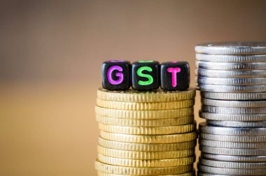 GST kavramı ile bir altın sikkeleri yığılmış blokta alfabesi.
