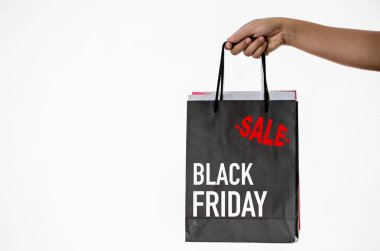 Black Friday alışveriş çantası üzerinde beyaz blackground tutan el.