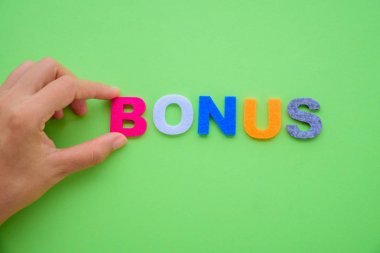 Soyut el Bonus alfabe kelime yeşil zemin üzerine yerleştir. 