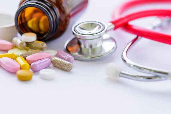 Soft focus pills with stethoscope and pill bottle background. 