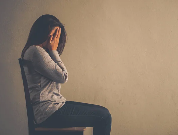 Depresif kadın evde karanlık odada bir sandalyede oturuyordu. — Stok fotoğraf