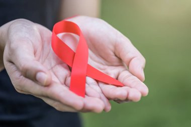  Bilinçlendirme kampanyası yardımcı olur. Kırmızı AIDS konusunda tutan eller