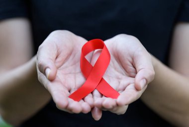 Kırmızı AIDS bilinçlendirme şerit tutan eller. 