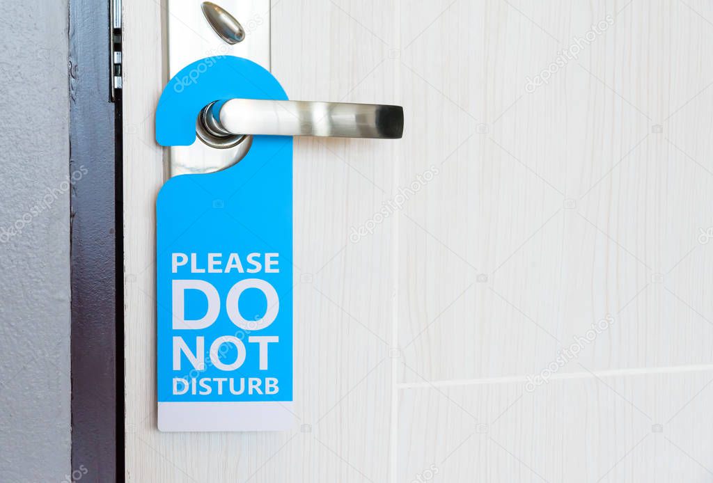 Signboard do not disturb hanging on the door.