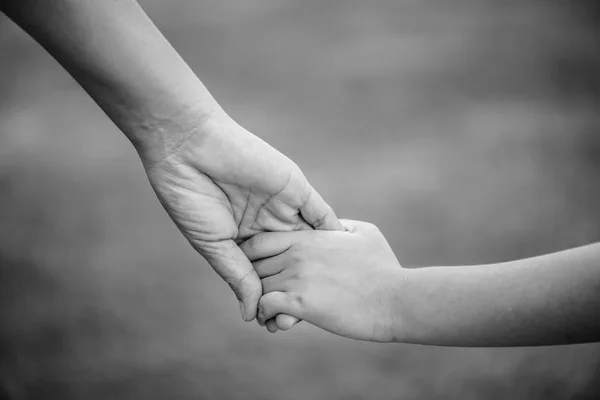 Black and white of mother holding a hand of his son. — Stock Photo, Image