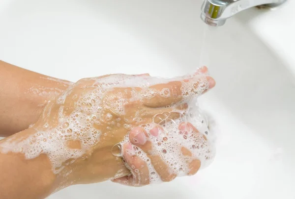 Kadın banyoda suyla musluk altında sabunla el yıkama. — Stok fotoğraf