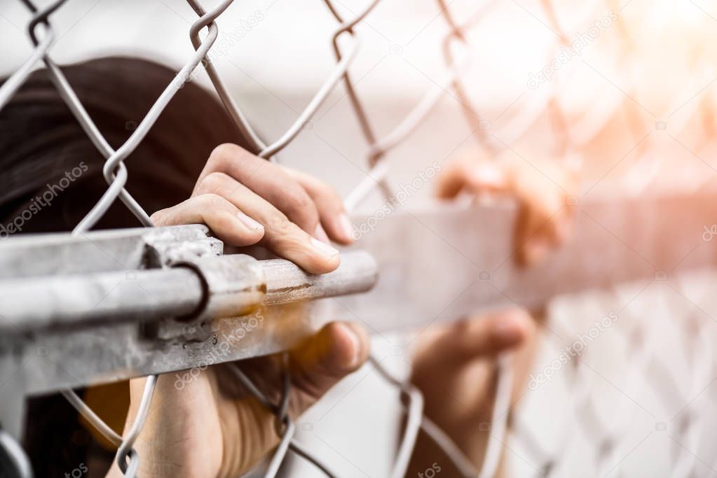 Woman hand holding on chain link fence