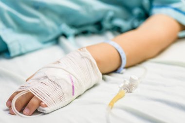 Tatlı çocuk el bir yatakta hastanede serum intravenöz uyur.