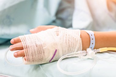 Tatlı çocuk el bir yatakta hastanede serum intravenöz uyur.