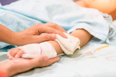 Çocuk el bir yatakta hastanede serum intravenöz uyur. 