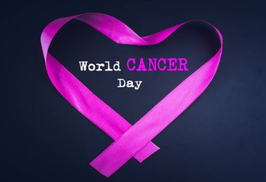 Siyah arka plan üzerine dünya kanser günü metin ile bir kalp şekli oluşturan mor şerit.