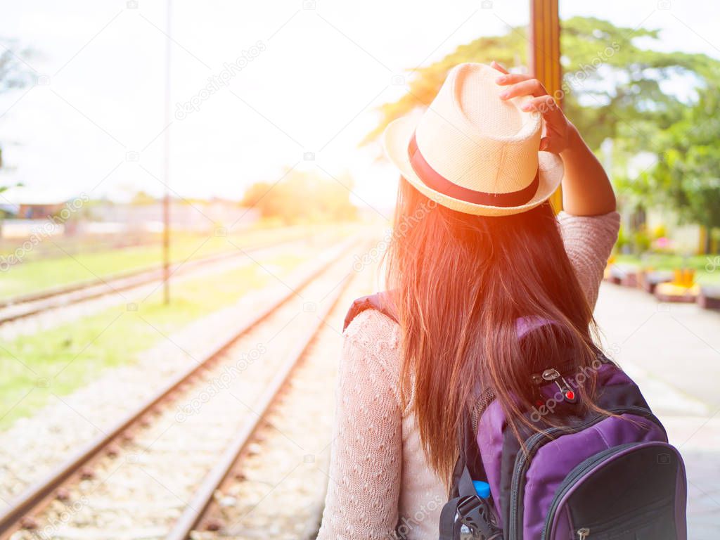 Traveler woman walking and waits train on the railway platform. Vacation and travel concept.