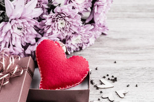 Un cuore rosso a forma di cuore di legno e fiore rosa — Foto Stock