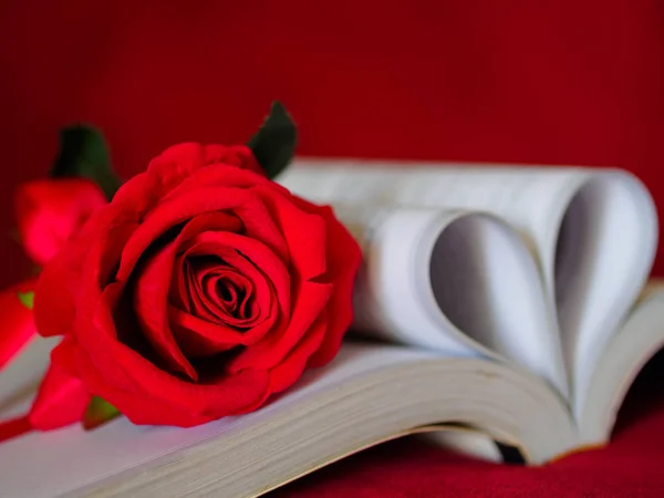 Estilo retro para rosa roja con páginas de un libro curvado en forma de corazón . — Foto de Stock