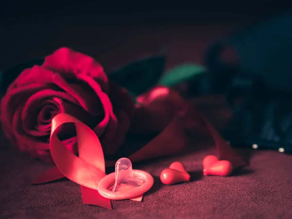 Chiave bassa del preservativo con rosa rossa, nastro rosso e cuori rossi  . — Foto Stock