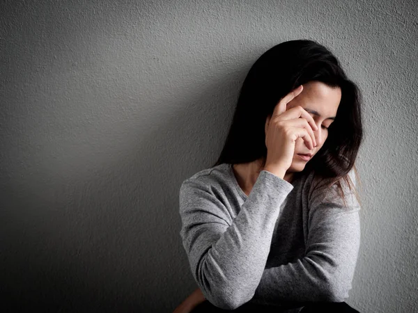 Deprimida mujer de corazón roto sentado solo en habitación oscura —  Fotos de Stock