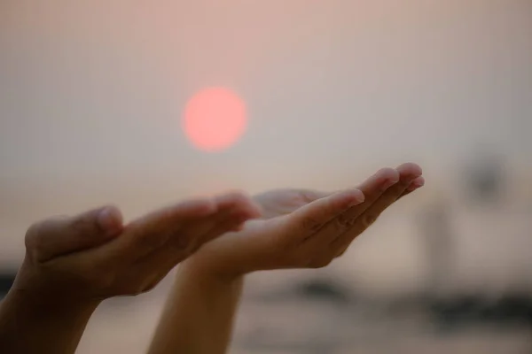 Руки крупным планом женщины молятся о благословении от Бога во время заката — стоковое фото