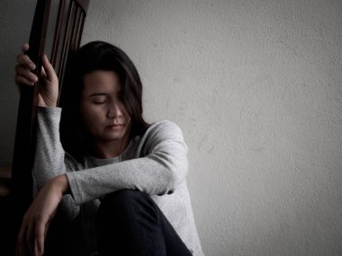 Depresif kırık kalpli kadın tek başına evde karanlık odada oturmak.