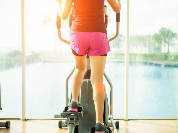 Close up woman legs working out on the exercise bike in fitness gym. exercise concept.