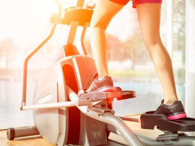 Fitness salonunda egzersiz bisikleti üzerinde çalışma dışarı kadın bacakları yukarı kapatın