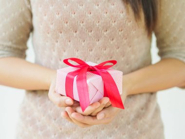 Bir hediye kutu kırmızı kurdele ile tutarak el. 