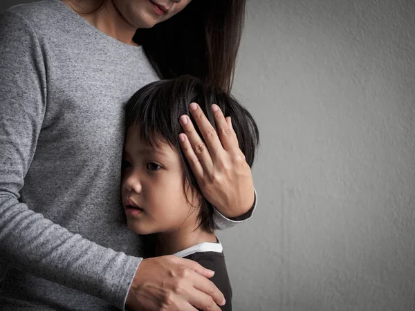 Sad little boy being hugged by his mother at home. — Stock Photo, Image