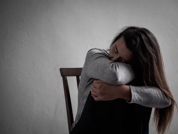 Depresif kırık kalpli kadın tek başına evde karanlık odada oturmak — Stok fotoğraf