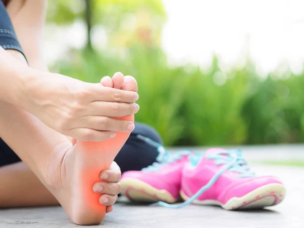 Mulher foco suave massageando seu pé doloroso durante o exercício . — Fotografia de Stock