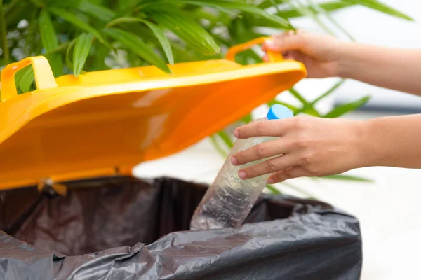 Zbliżenie dłoni oddanie Odpady plastikowe butelki do kosza na śmieci — Zdjęcie stockowe