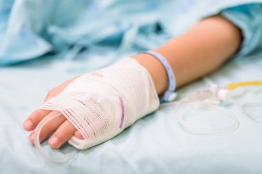 Tatlı çocuk el ile serum fizyolojik intravenöz, seçici odak hastanede bir yatakta uyuyor.