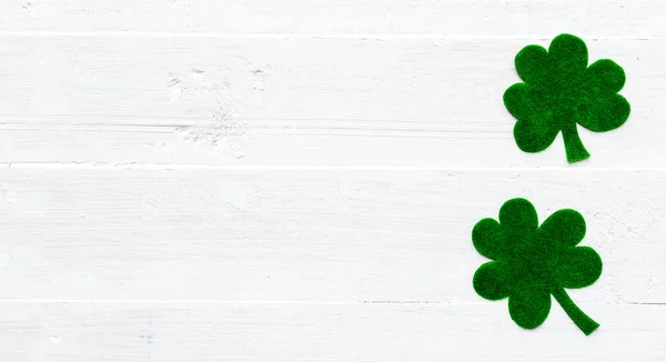 Happy St Patricks Day meddelande och en massa grönbok klöver blad på vit trä bakgrund — Stockfoto