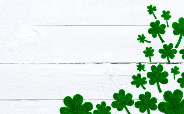 Happy St Patricks Günü mesajı ve yeşil kağıt yonca yaprağı Beyaz ahşap zemin üzerinde bir sürü — Stok fotoğraf