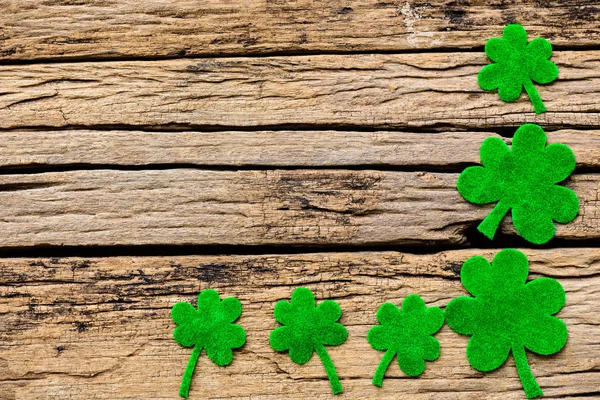 Feliz día de San Patricio mensaje sobre el trébol de papel verde y fondo de madera blanca —  Fotos de Stock