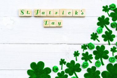 Happy St Patricks Günü mesajı ve yeşil kağıt yonca yaprağı Beyaz ahşap zemin üzerinde bir sürü