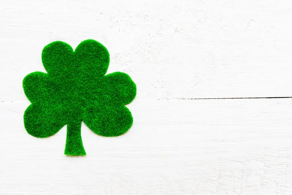 Feliz día de San Patricio mensaje sobre el trébol de papel verde y fondo de madera blanca —  Fotos de Stock