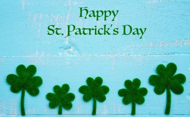 Arka plan doku mutlu St Patricks Günü mesajı ve bir sürü yeşil kağıt yonca yaprağı Pastel beyaz ve mavi ahşap masa.
