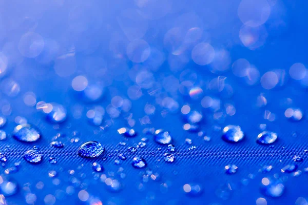 Feche o padrão de gotas de água sobre um fundo de pano impermeável azul. Conceito do Dia Mundial da Água . — Fotografia de Stock
