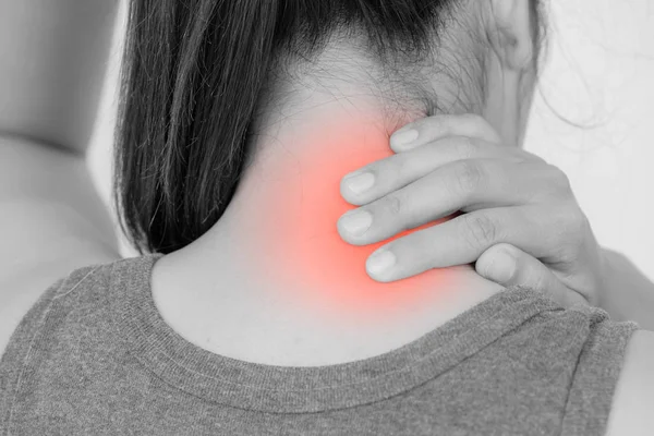 Primo piano donna dolore al collo e alle spalle e lesioni con riflessi rossi sulla zona del dolore. Assistenza sanitaria e concetto medico . — Foto Stock